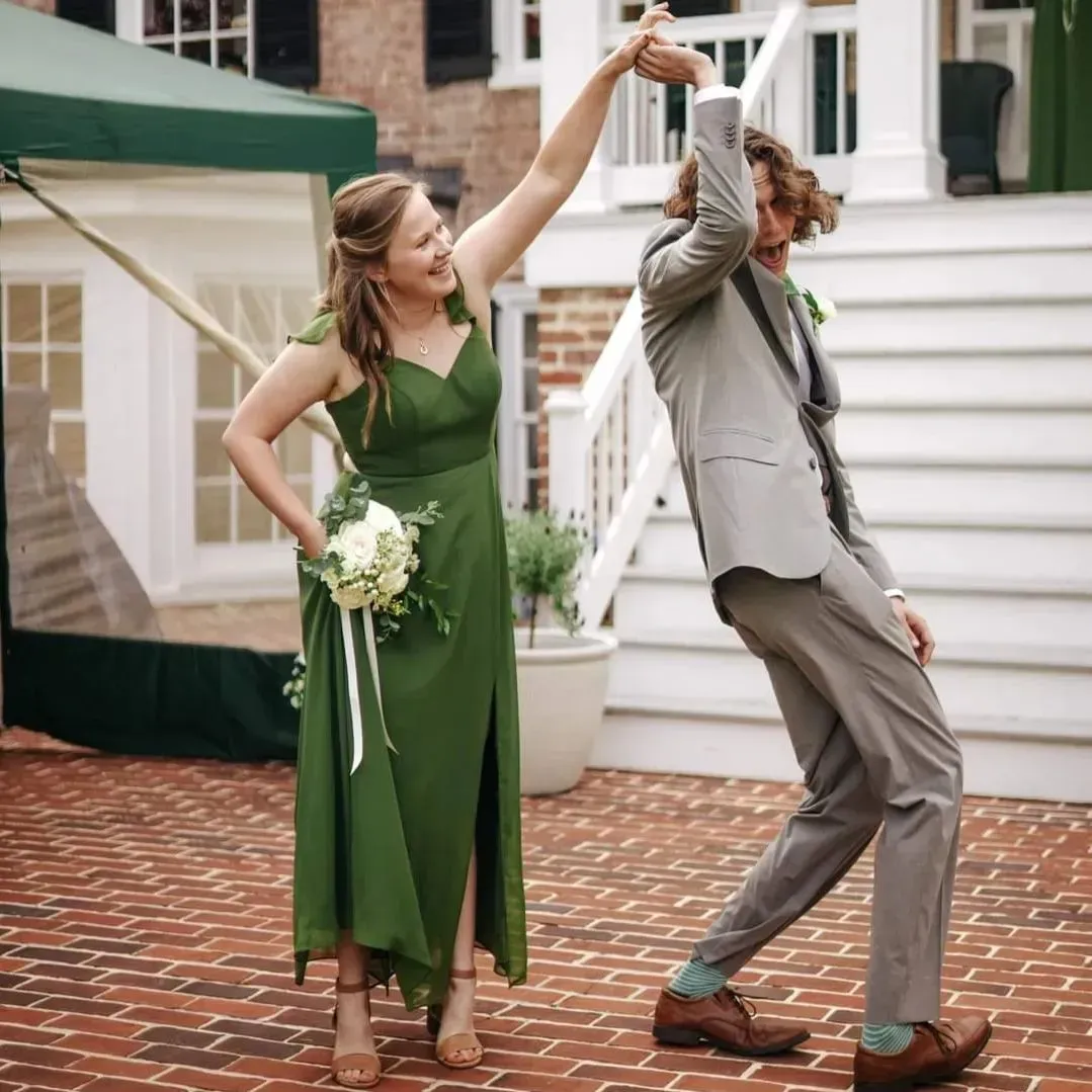 A woman in a green dress is dancing with a man in a suit