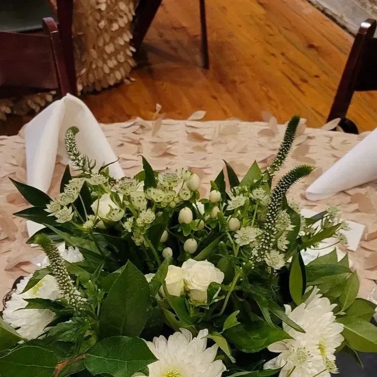 A table with white flowers and green leaves on it