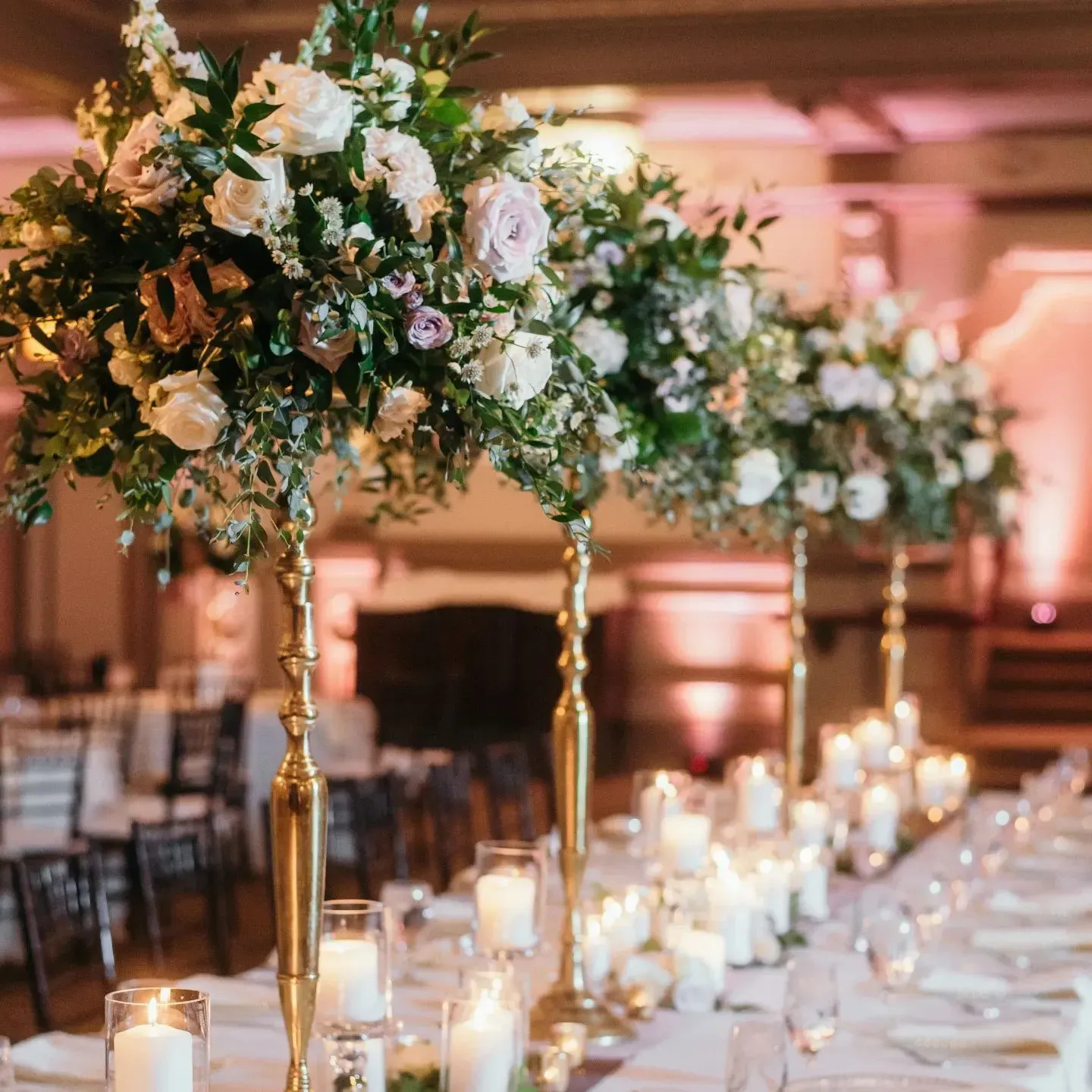 A long table with flowers and candles on it.