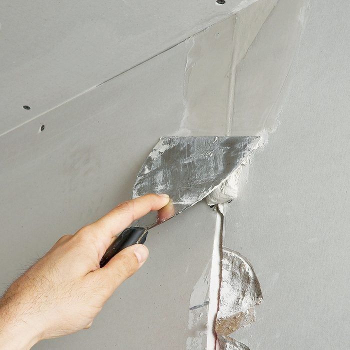 A person is plastering a wall with a spatula.