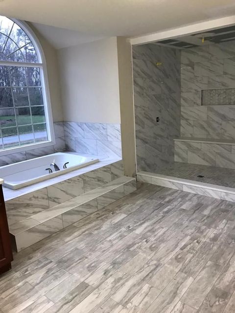 A bathroom with a tub and a walk in shower.