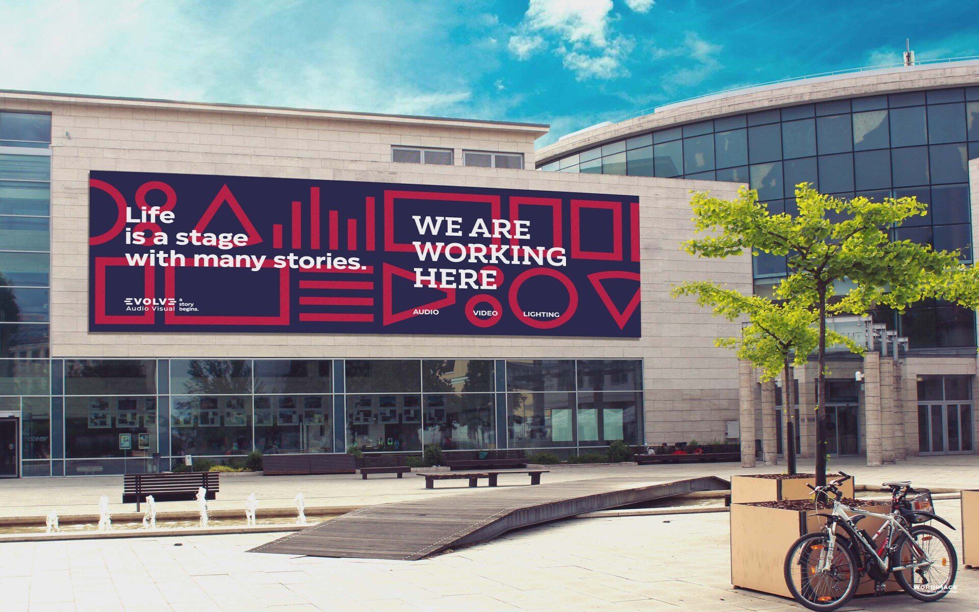 A large sign on the side of a building says we are working here
