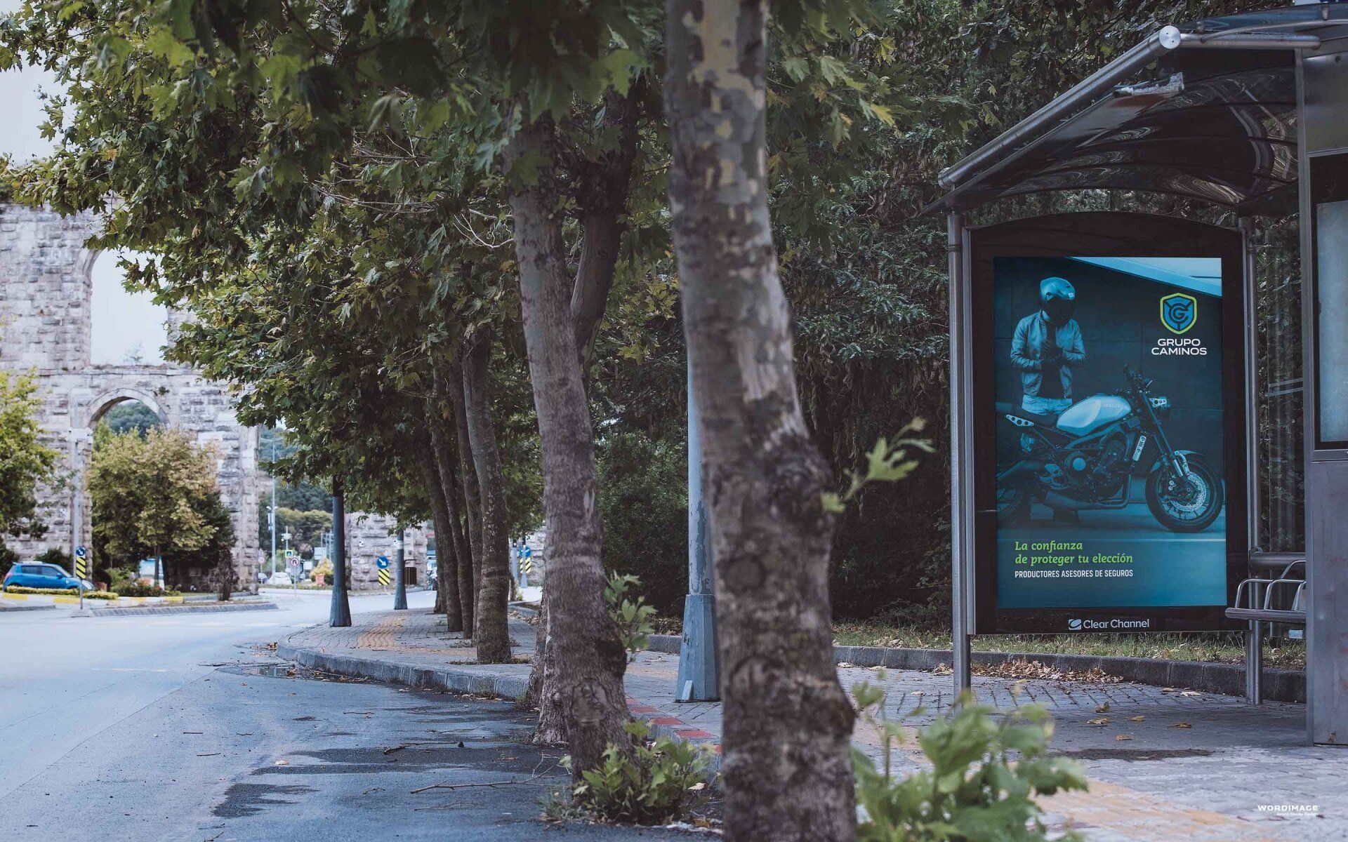 A bus stop with a poster of a man riding a motorcycle on it.
