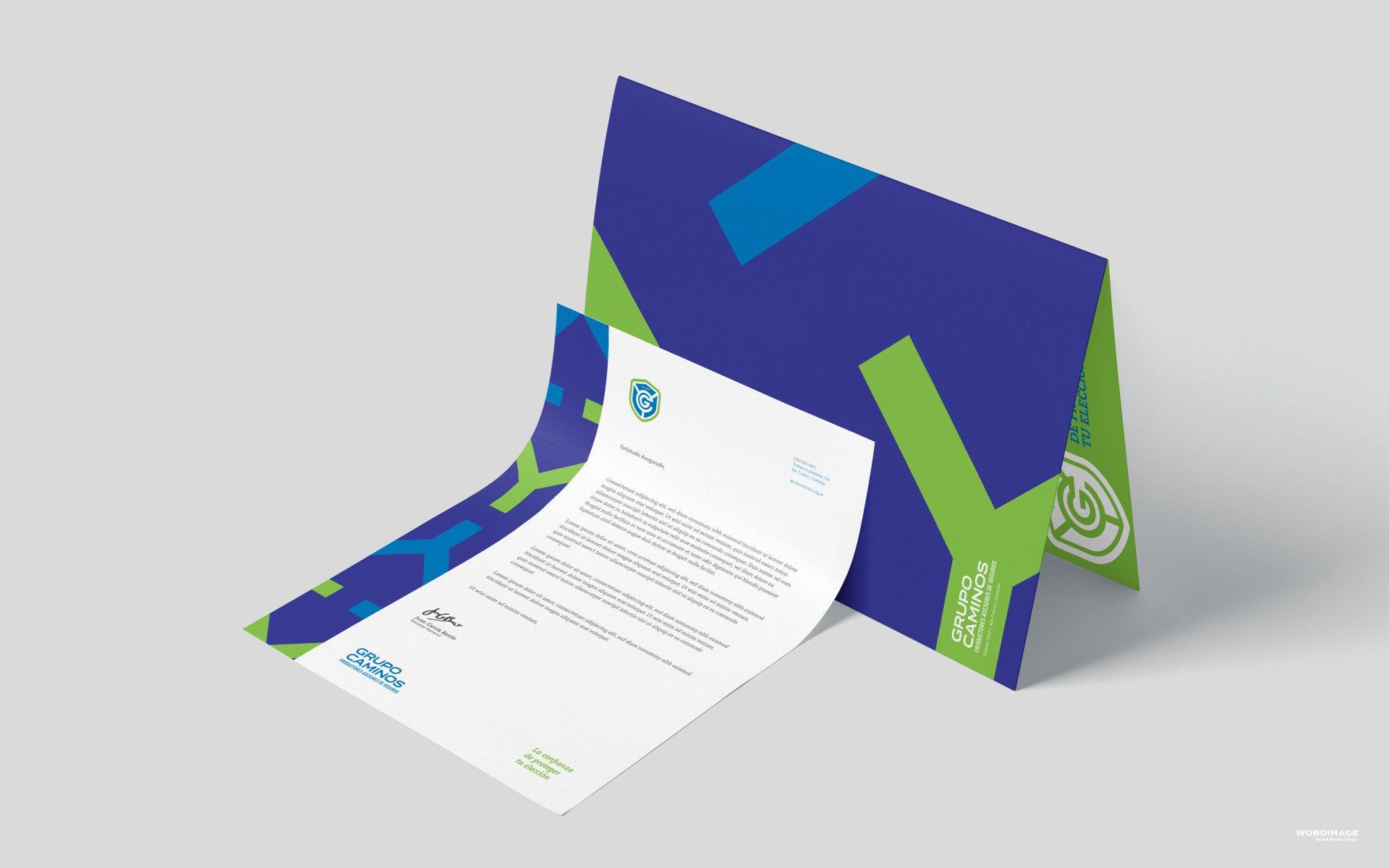 A letter is sitting on top of a blue and green envelope.