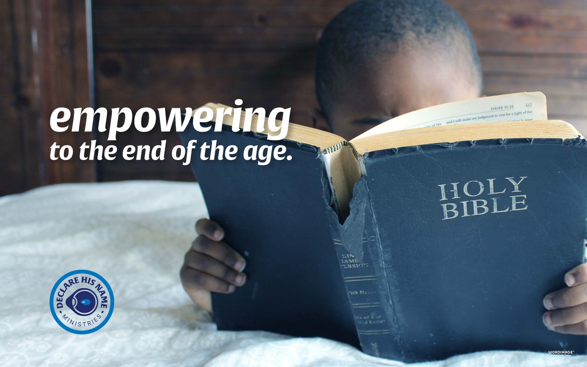 A child is reading a holy bible on a bed