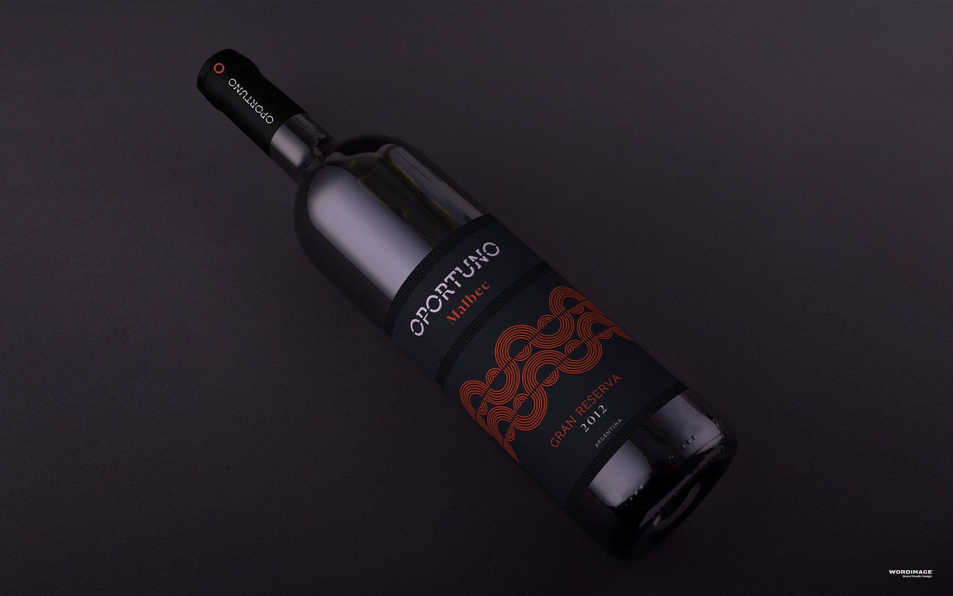 A bottle of wine with a black label is sitting on a table.