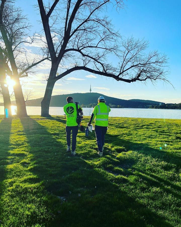 Two Electricians Walking on Grass