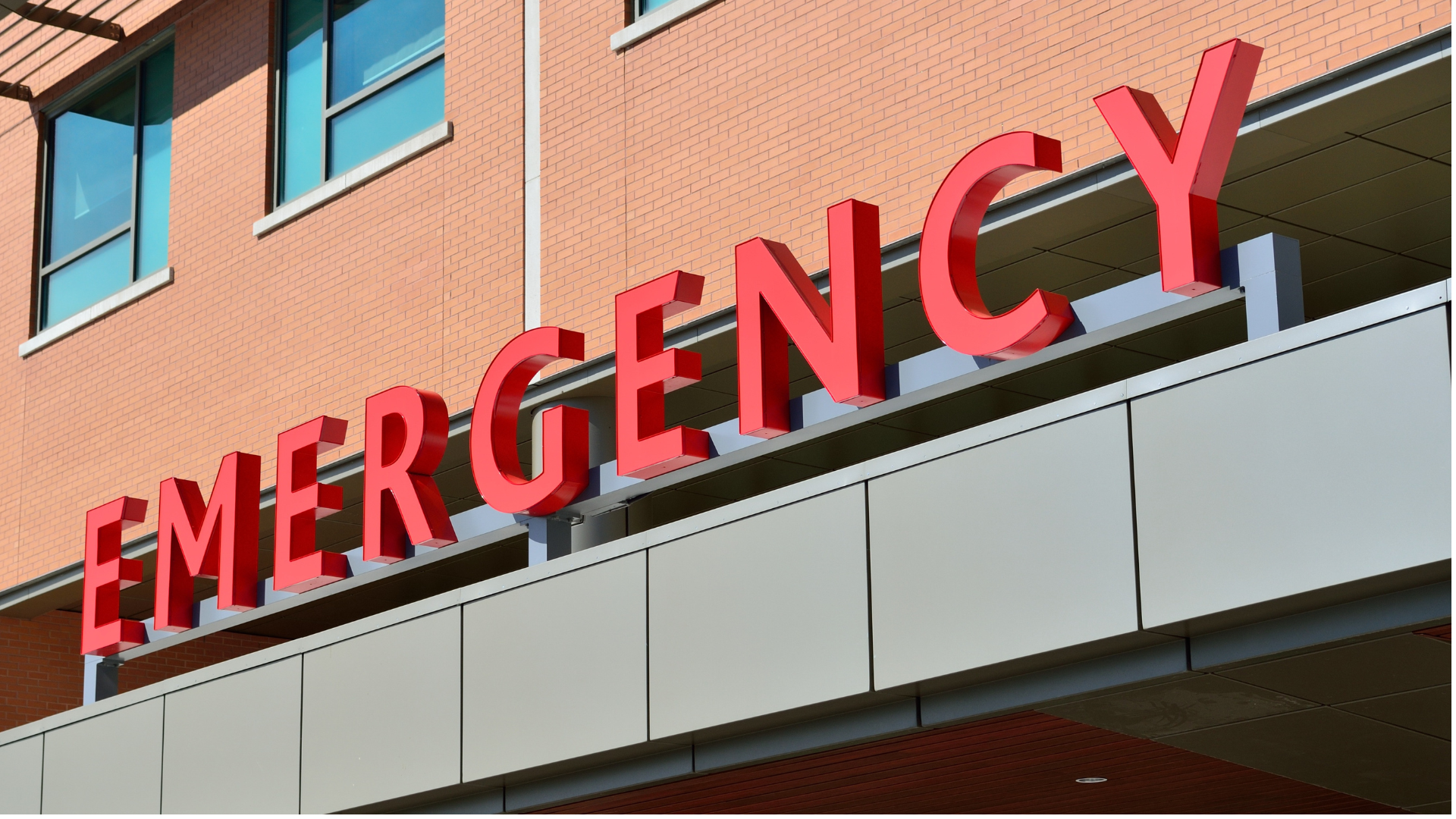 Red EMERGENCY sign on a hospital building exterior