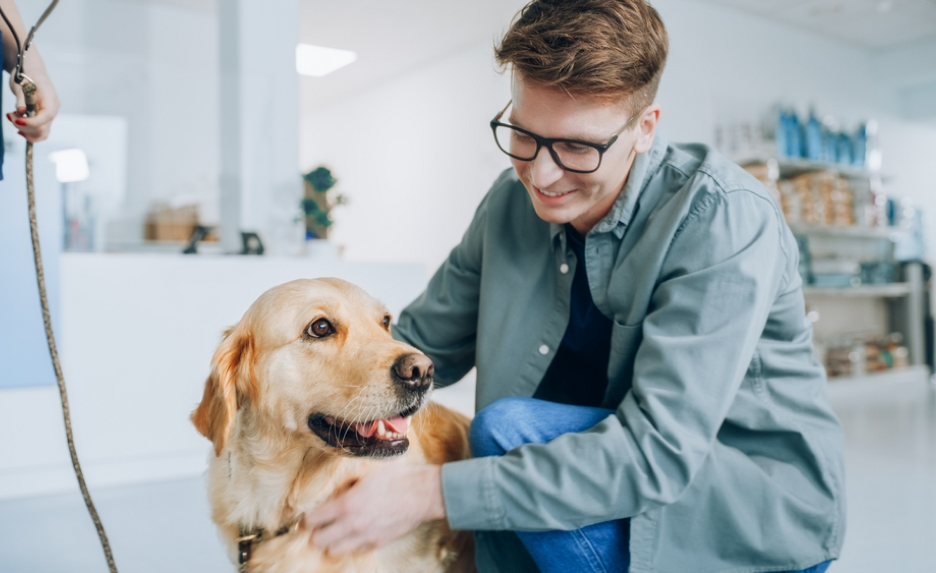 A man is petting a dog in a veterinary clinic.