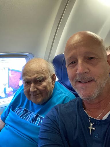 Two men are sitting next to each other on an airplane.