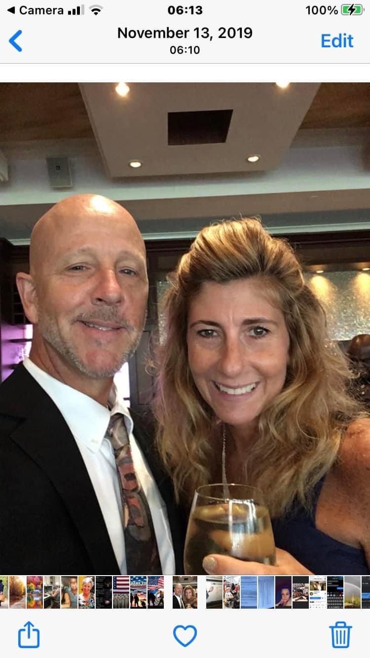 A man and a woman are posing for a picture on a cell phone.
