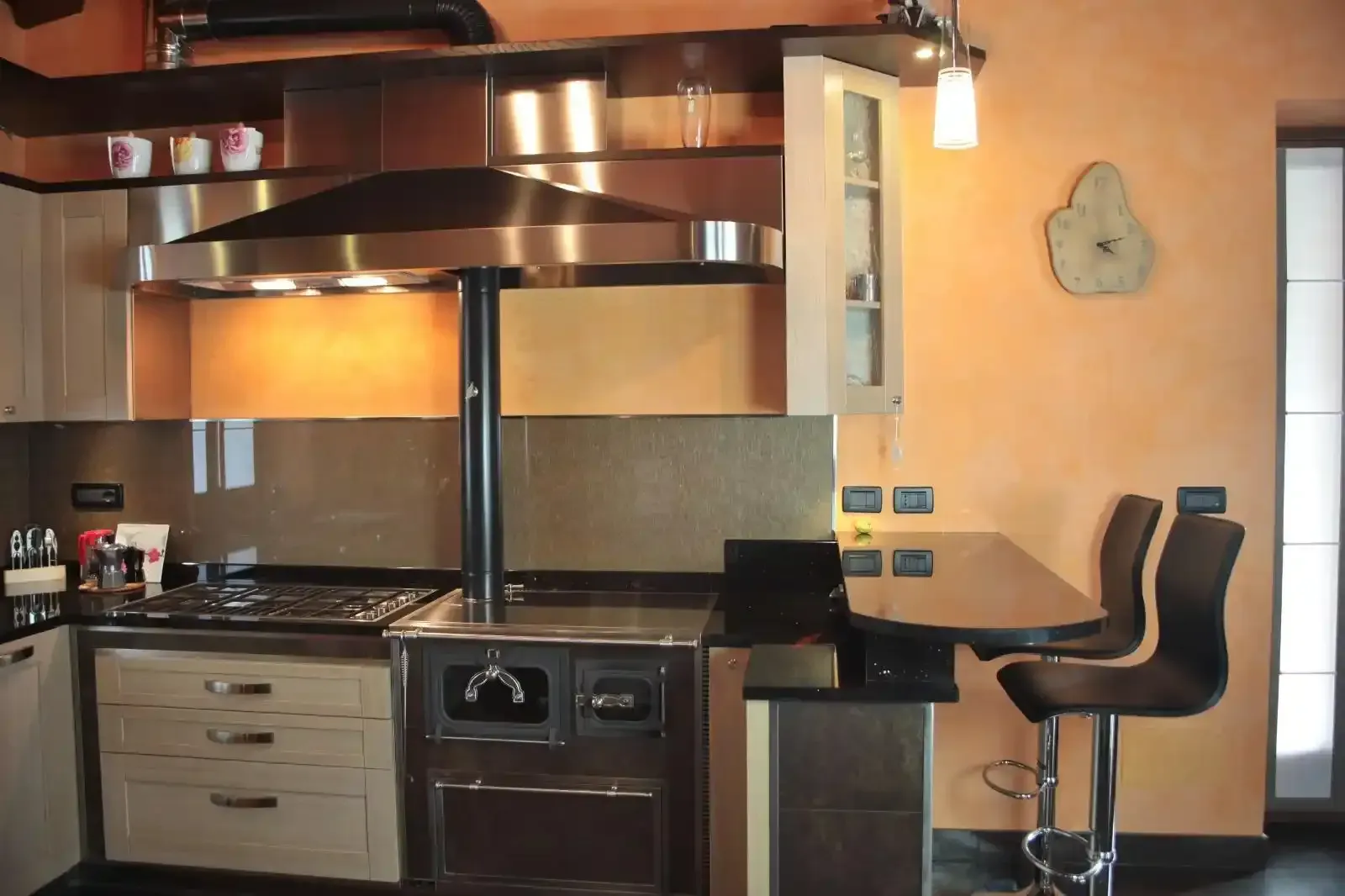 Donna che cucina su una stufa in maiolica rossa in una cucina luminosa con pavimenti in legno.