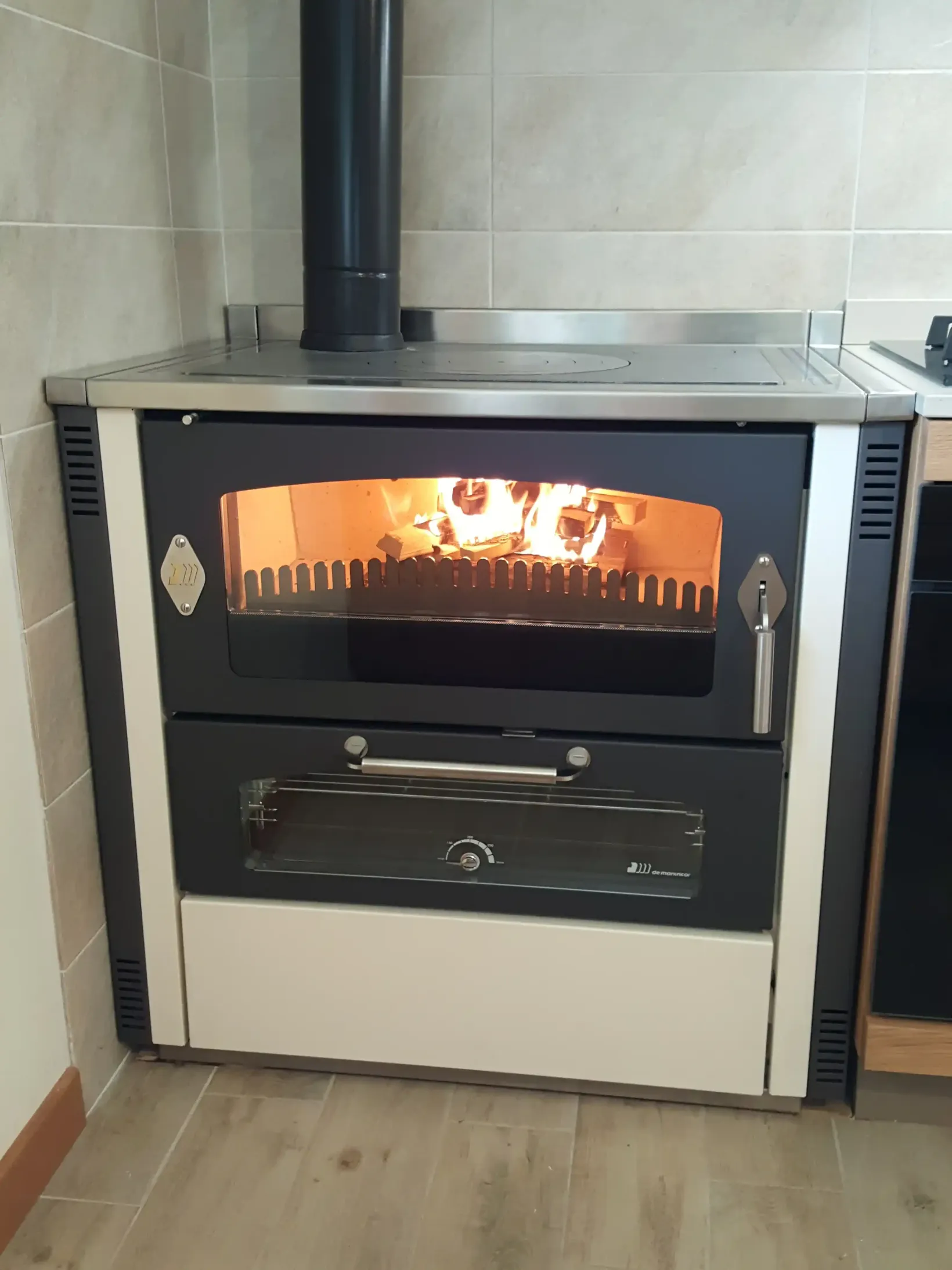 Stufa a legna con fuoco acceso. In bianco e nero, in un ambiente cucina.