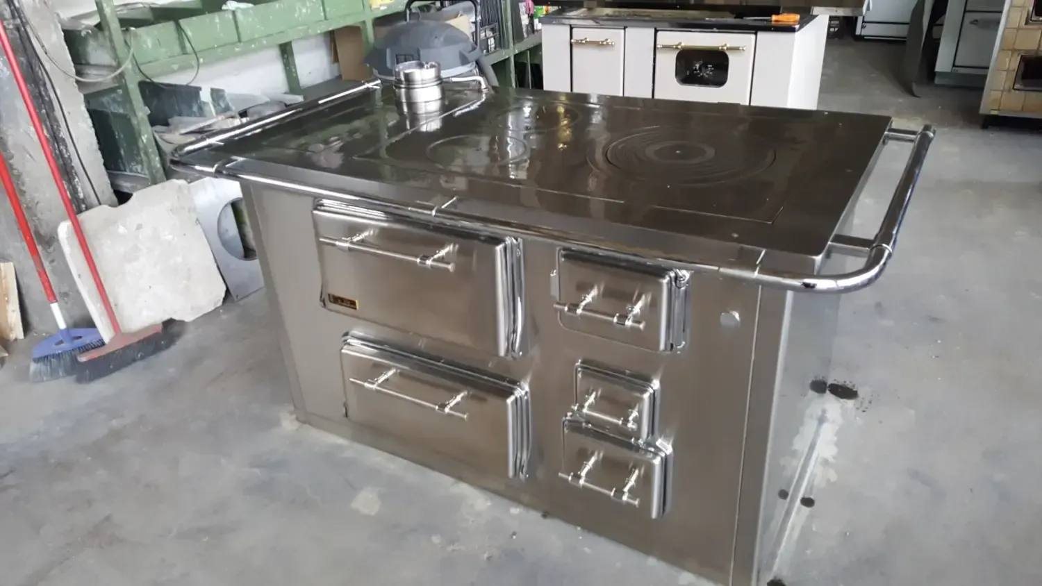 Cucina commerciale in acciaio inox con più forni e piano cottura liscio.