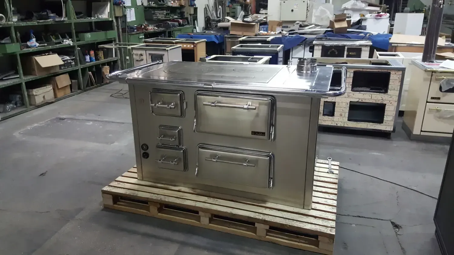 Stufa industriale in acciaio inossidabile su un pallet di legno in un magazzino.