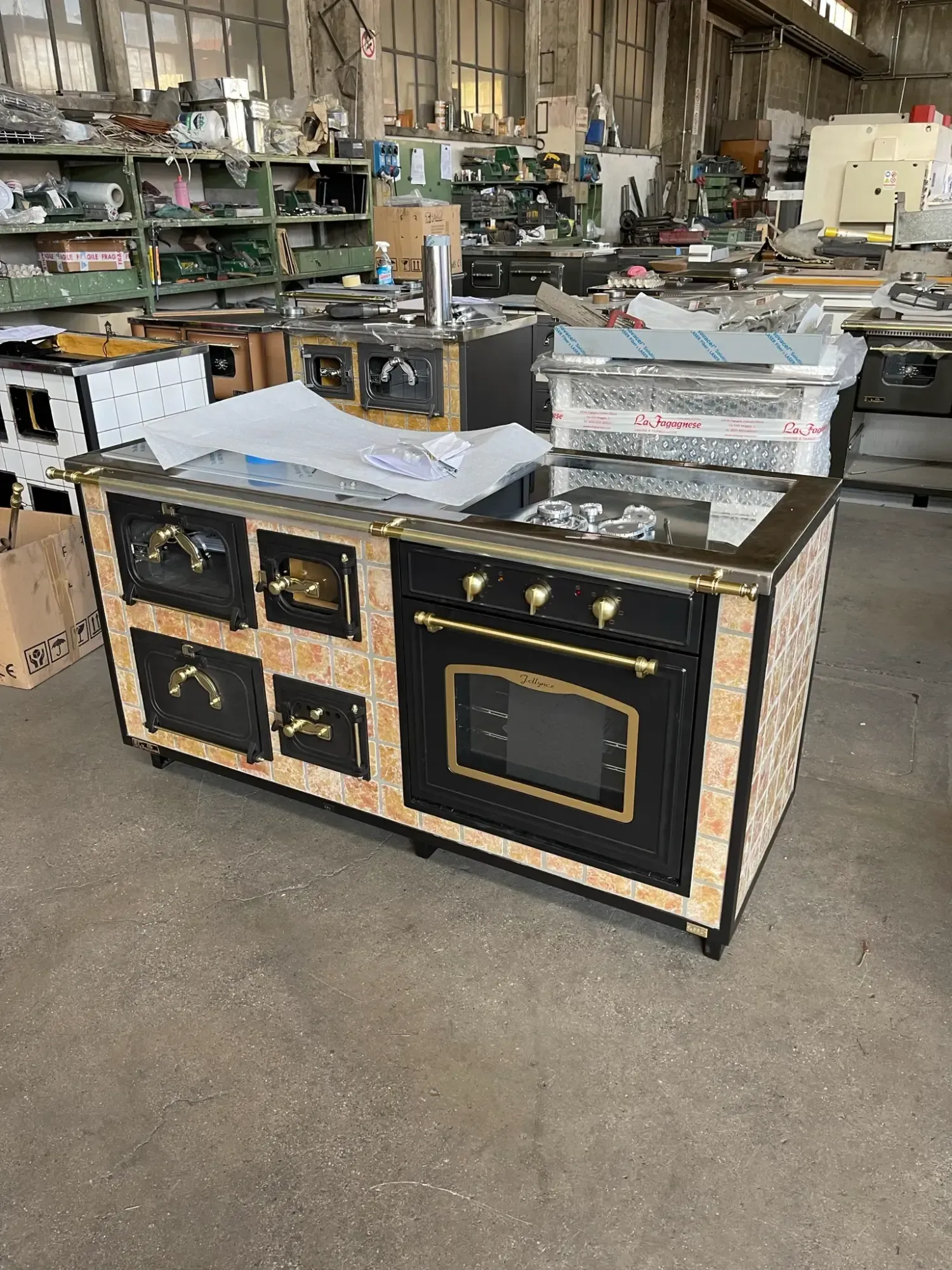 Una grande cucina decorata in nero e oro con forno e fornelli multipli, ambientata in un laboratorio.