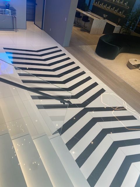 Black-and-white chevron floor design in a modern interior with glass panels and seating area