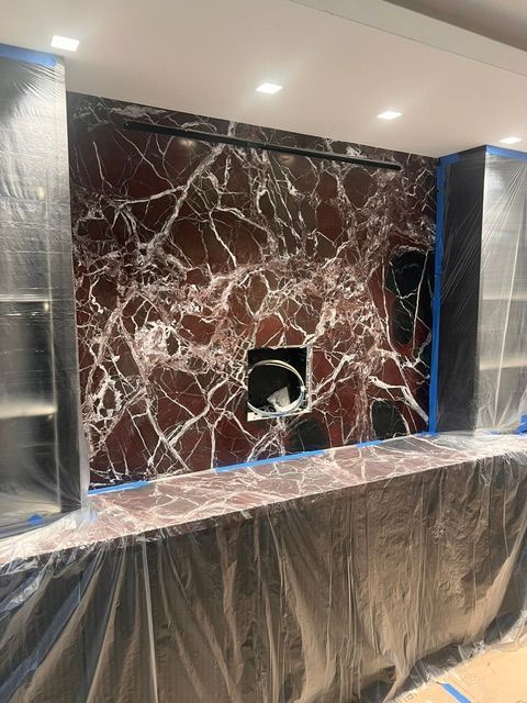 Marble-clad wall with central circular opening and two side niches, in a room under renovation