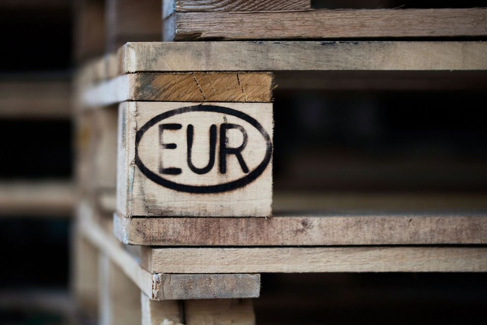 Primo piano di un pallet di legno impilato con la sigla