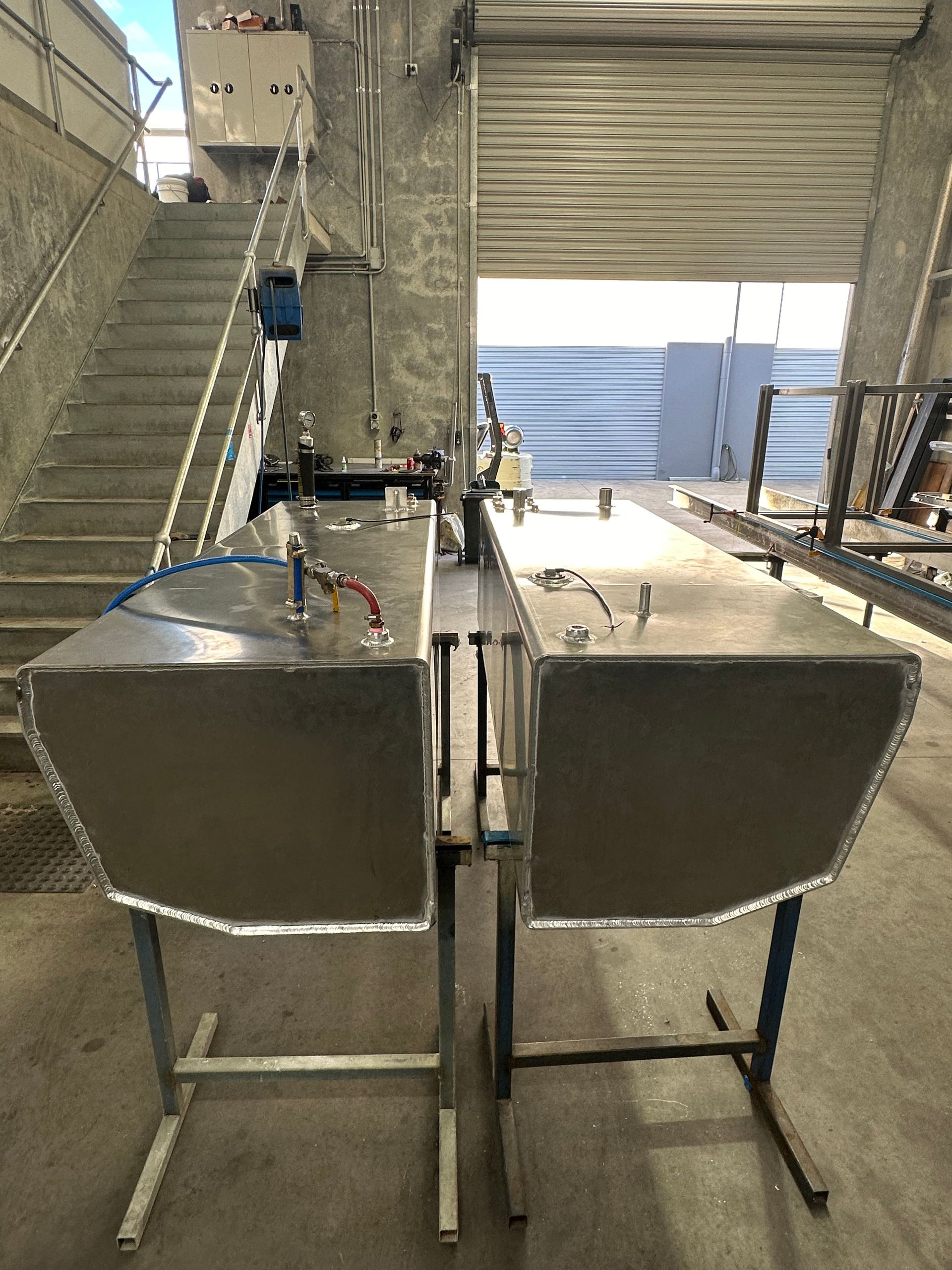 Two Stainless Steel Industrial Bins on A Metal Frame Under a Covered Stairway — EB Metalworks in Somersby, NSW