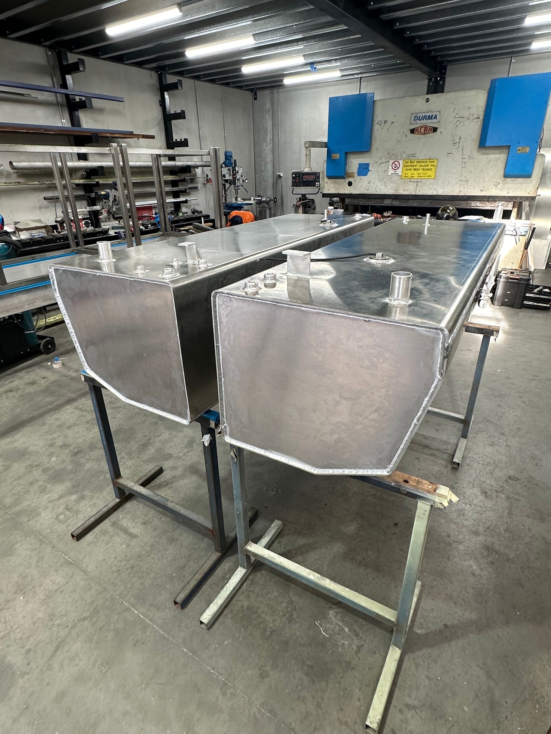 Two Silver Metal Troughs on Stands in A Workshop, with Tools and Shelves in The Background — EB Metalworks in Somersby, NSW