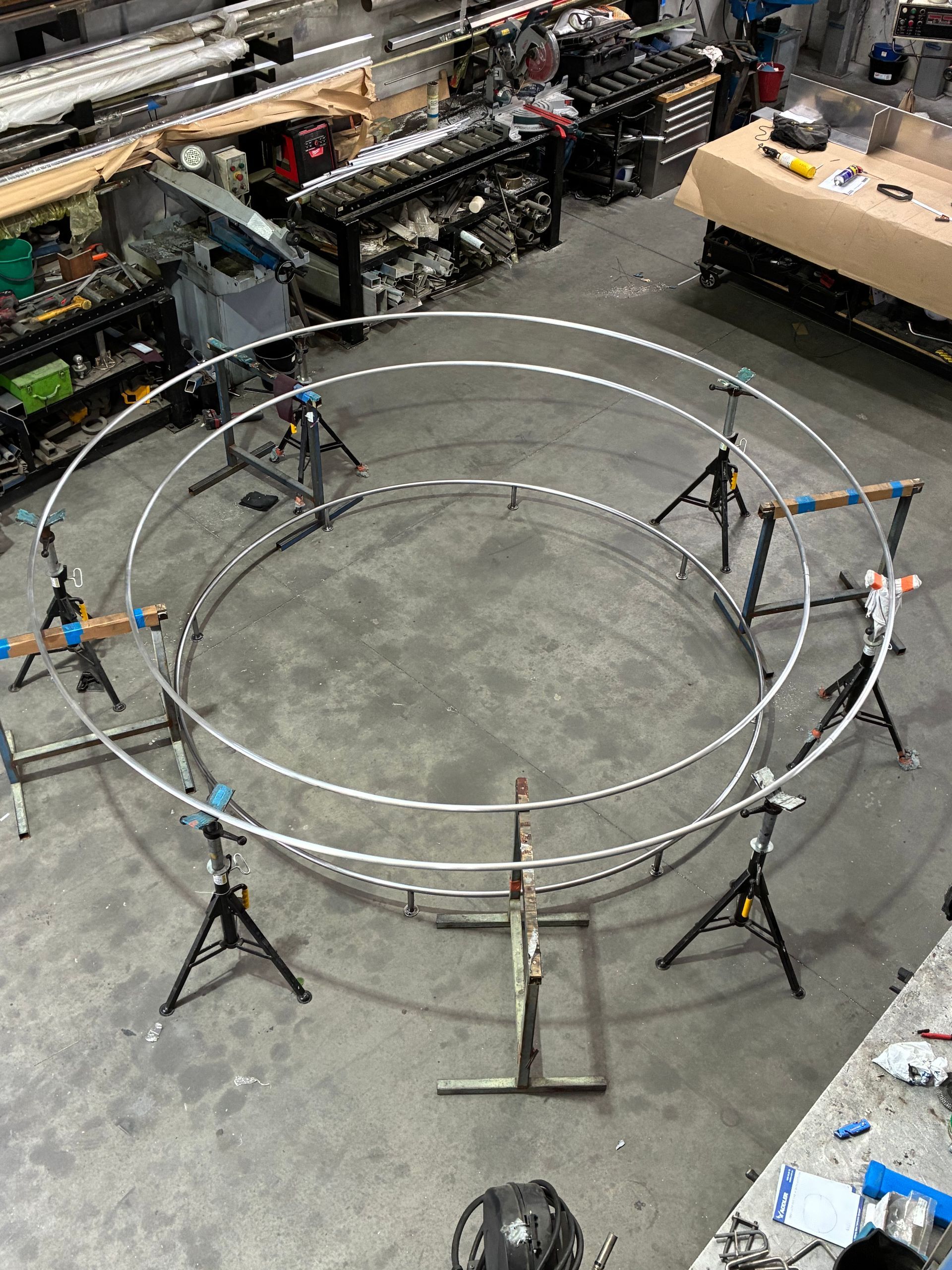 Workshop Floor with A Large Circular Metal Frame on Stands and Tools Around It — EB Metalworks in Newcastle, NSW