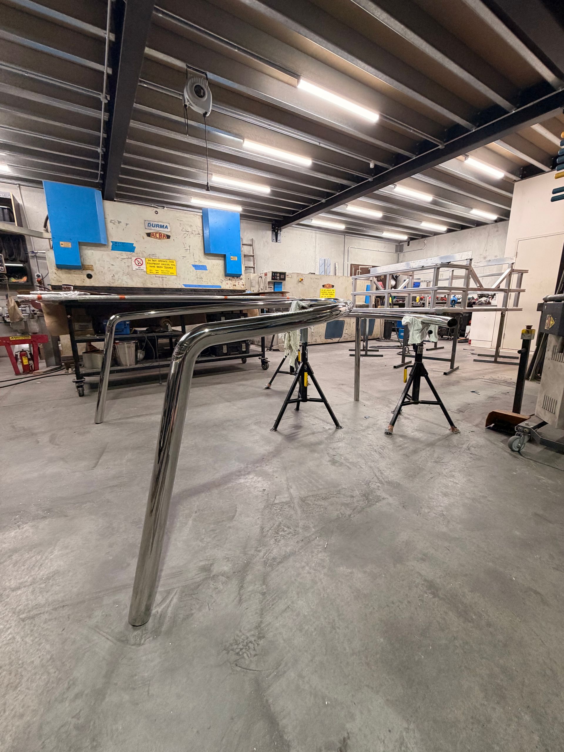 Industrial Workshop with Metal Frames on Sawhorses Under Bright Overhead Lights — EB Metalworks in Eastern Creek, NSW