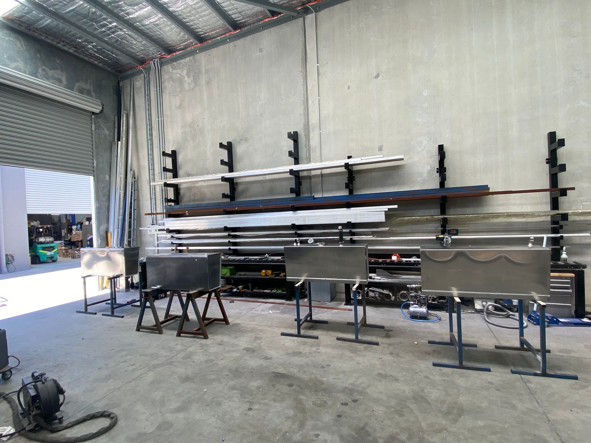 Industrial Workshop Interior with Metal Shelves, Pipes, and Equipment on A Concrete Floor — EB Metalworks in Gosford, NSW