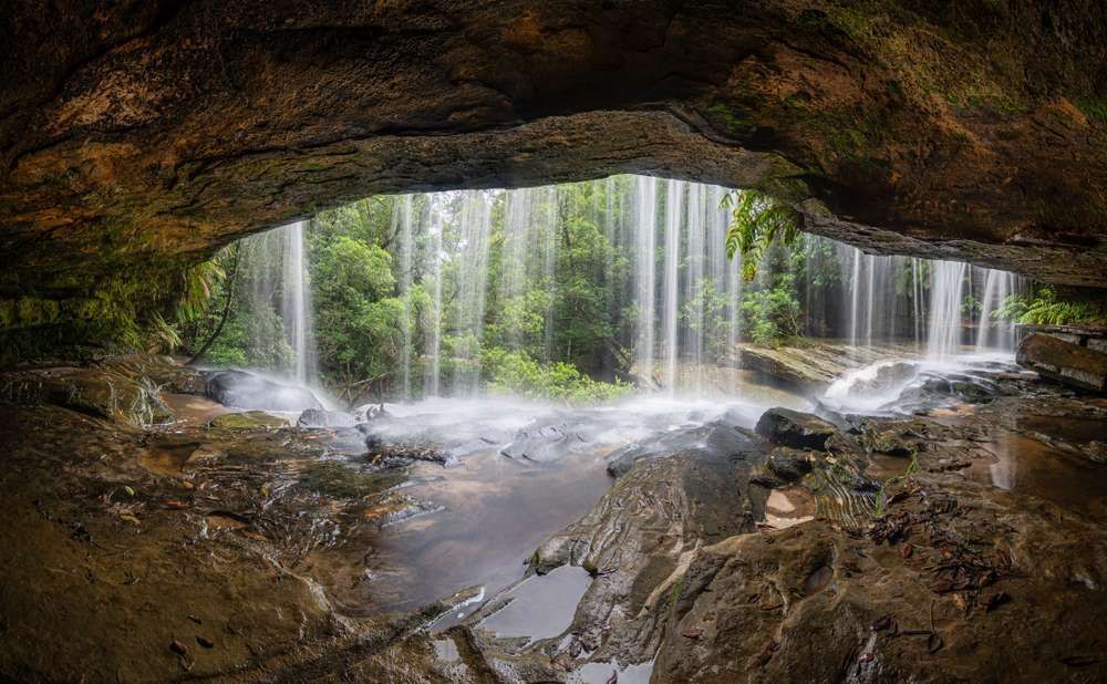 A Waterfall is Coming Out of a Cave in the Woods — EB Metalworks in Somersby, NSW