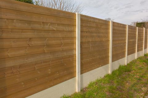 A wooden fence is sitting in the middle of a grassy field.