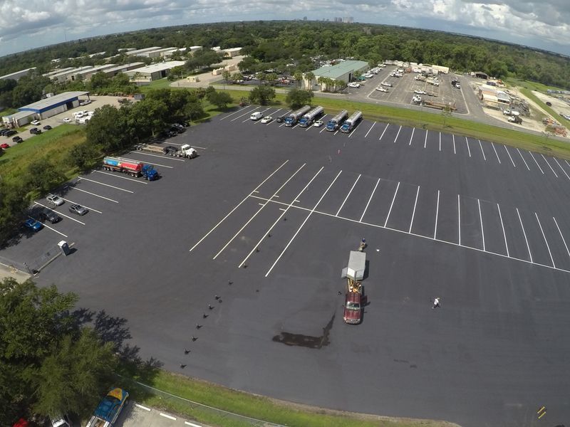 An aerial view of a parking lot filled with cars and trucks.