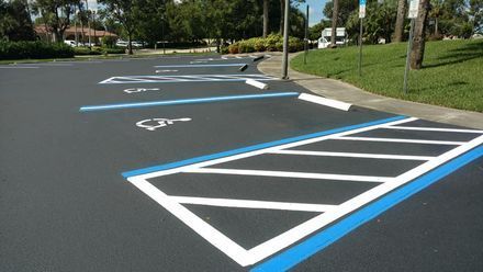 A parking lot with blue and white lines and a handicapped parking space.