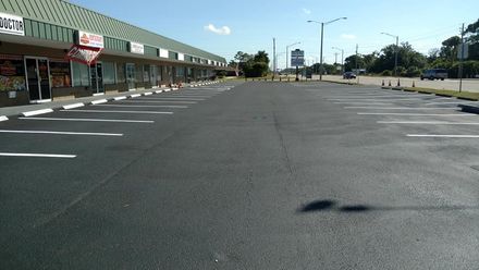 An empty parking lot in front of a shopping center