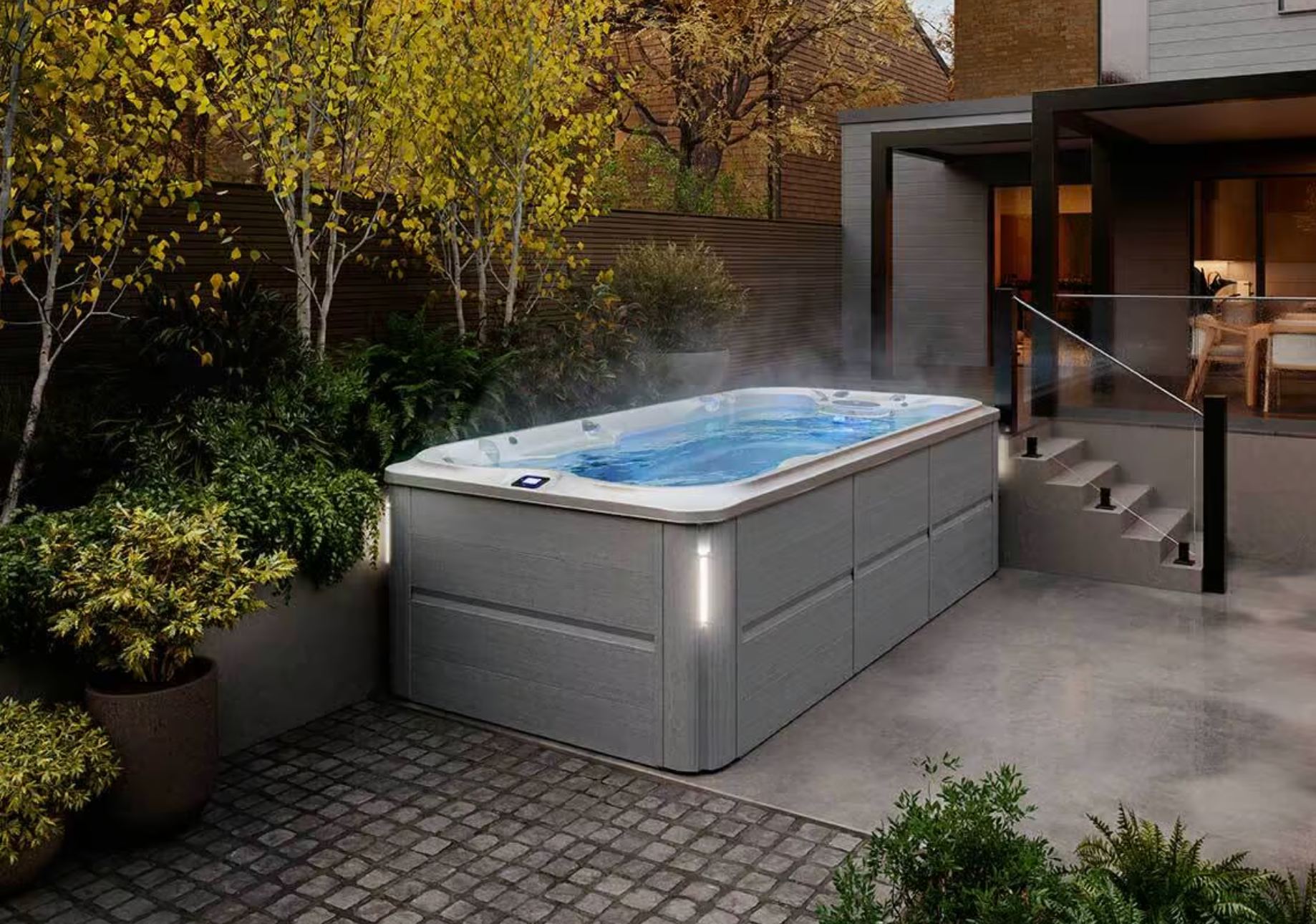 Une grande piscine est située sur un patio à côté d'une maison.