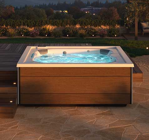 Un bain à remous en bois est posé sur un sol carrelé.