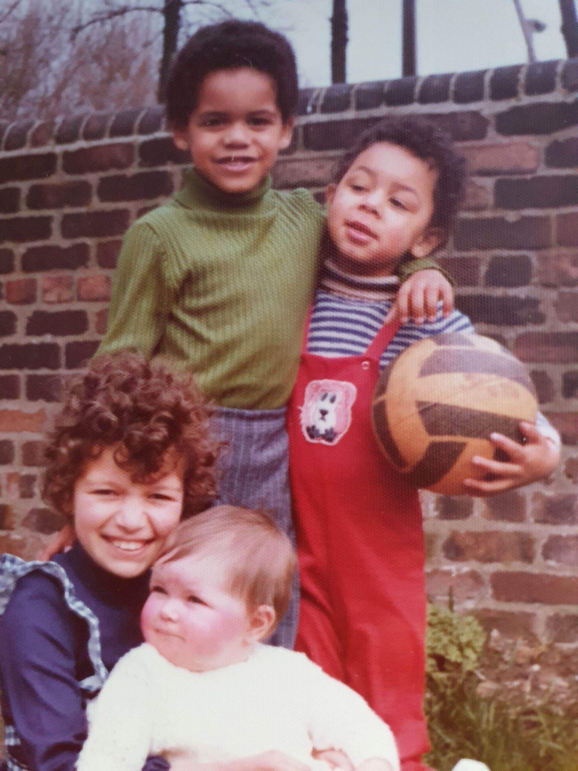 Four siblings in their garden with their arms around one another