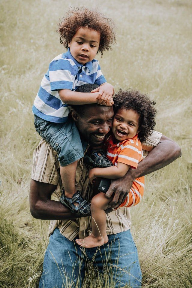 in-celebration-of-the-sparent-blog-post-picture-shows-smiling-adult-carrying-two-children