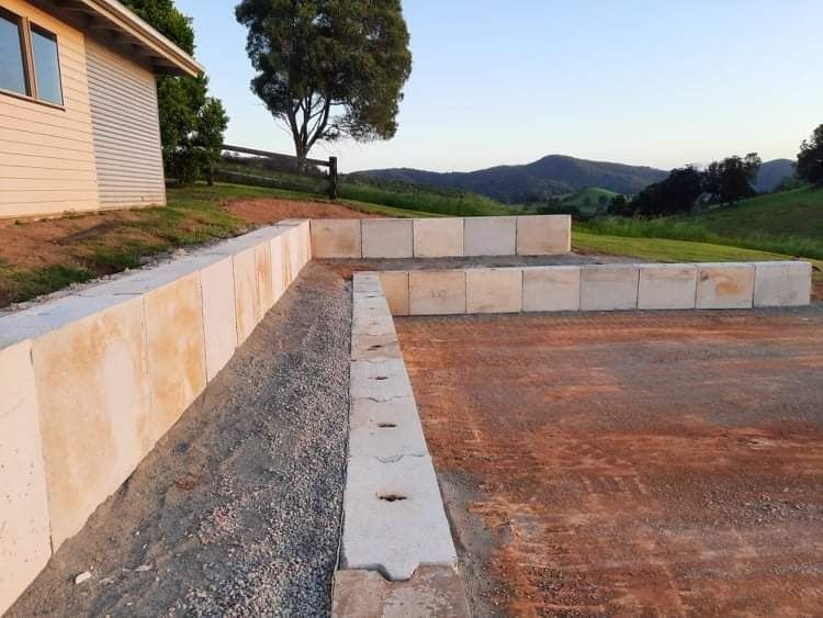 A Concrete Wall Is Being Built in Front of A House — CK's Milling & Earthworks in Bells Bridge, QLD