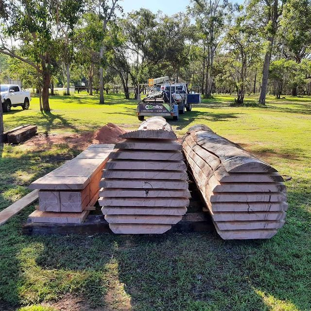 Two Logs Are Stacked on Top of Each Other in A Field — CK's Milling & Earthworks in Bells Bridge, QLD
