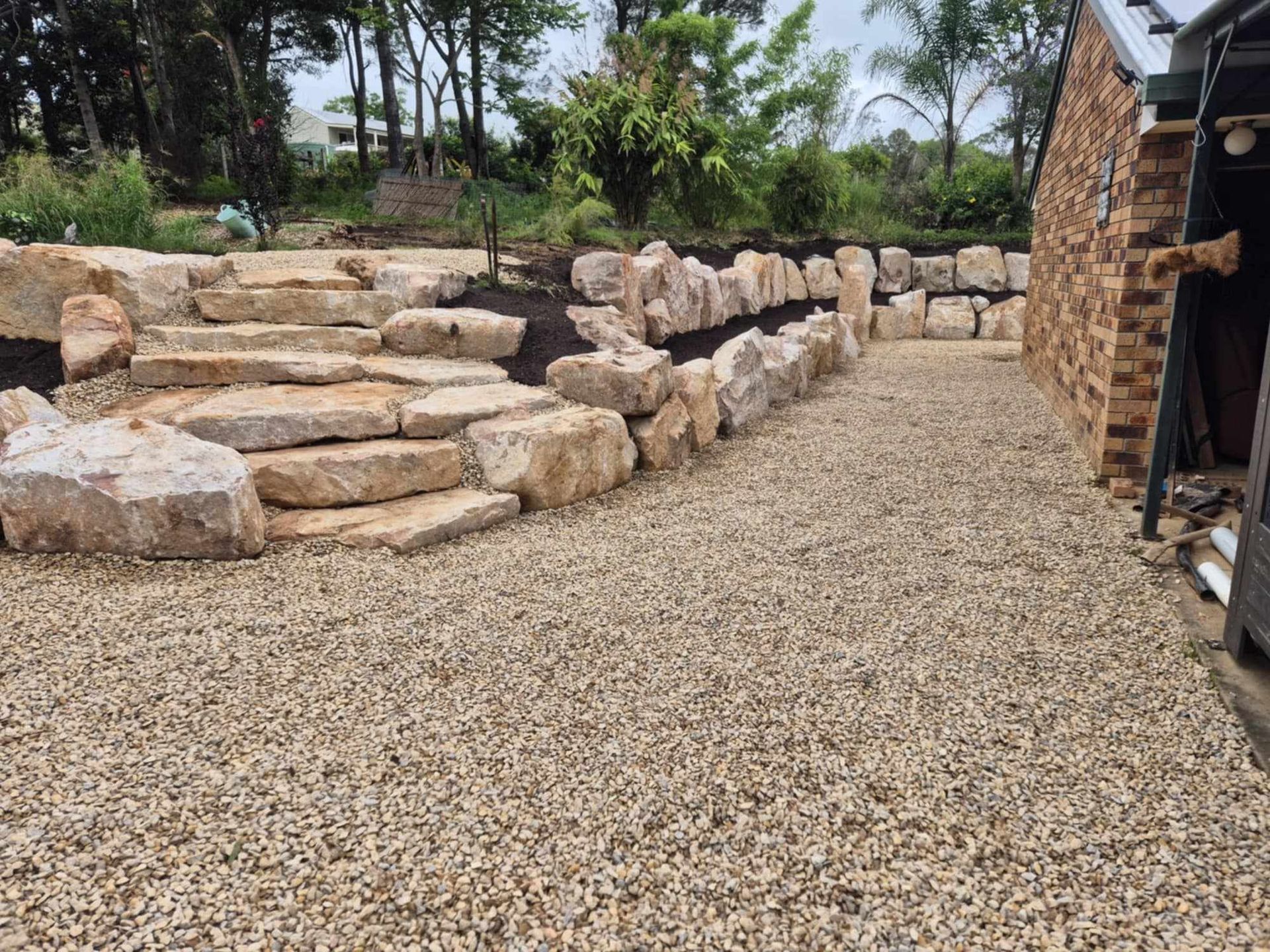 A Stone Wall With Stone Steps Is In A Backyard — CK's Milling & Earthworks in Bells Bridge, QLD