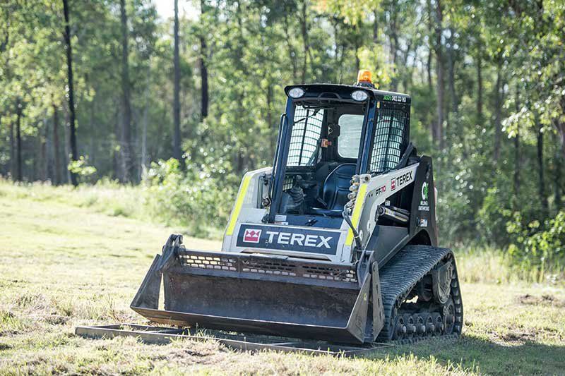 A Small Bulldozer Is Driving Through a Grassy Field — CK's Milling & Earthworks in Maryborough, QLD