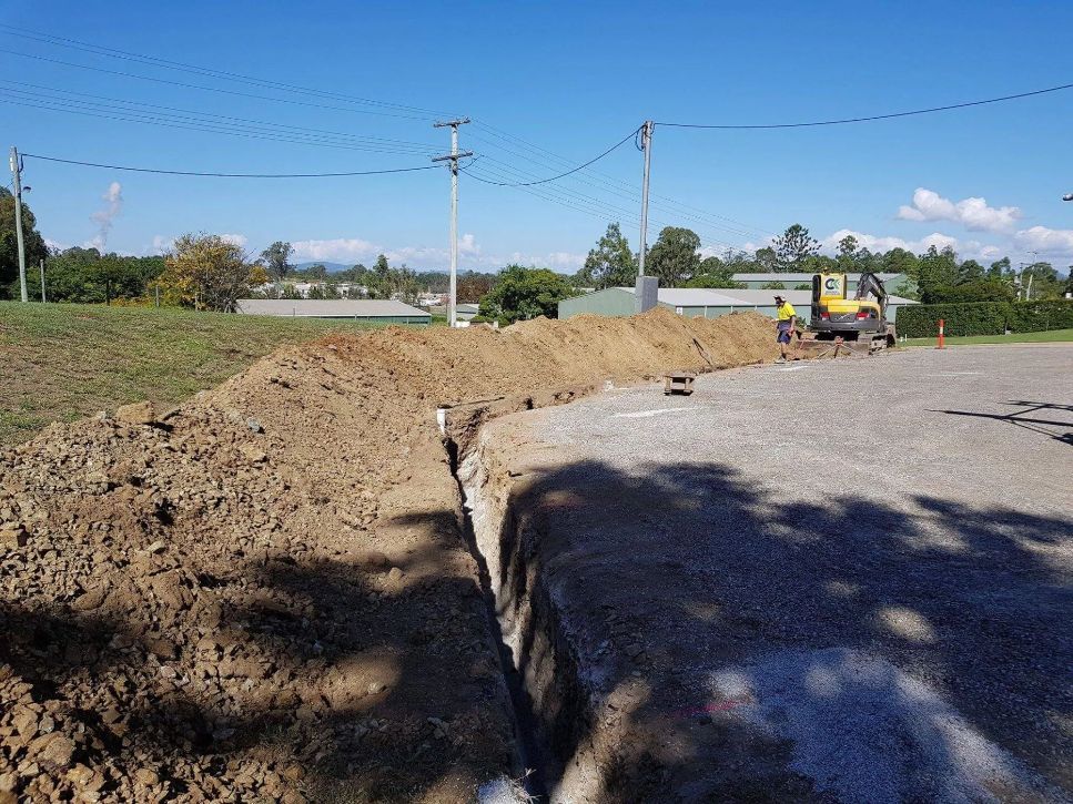 A Construction Site with A Large Pile of Dirt and A Truck in The Background — CK's Milling & Earthworks in Bells Bridge, QLD