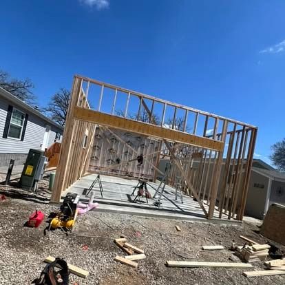 A garage is being built in the backyard of a house.