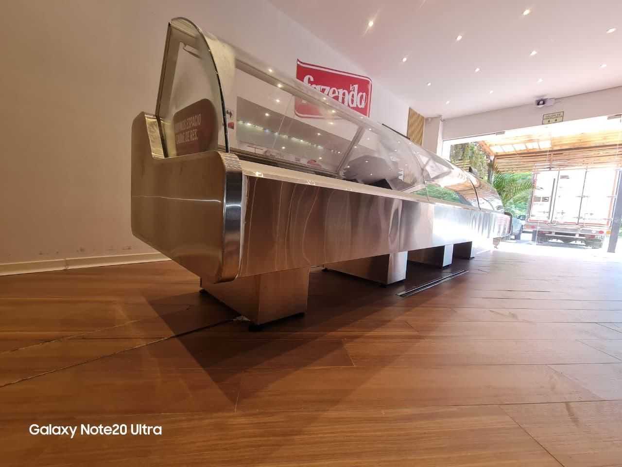Mostrador de buffet de acero inoxidable en un luminoso comedor interior con suelo de madera.