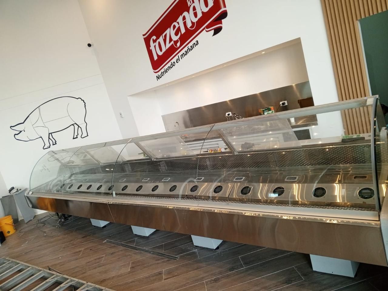 Vitrina vacía de helados en una tienda de postres con un letrero rojo encima.