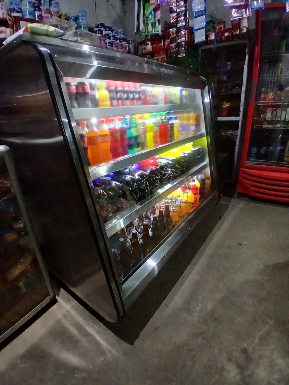 Vitrina refrigerada con coloridas bebidas embotelladas en el pasillo de una tienda de conveniencia.