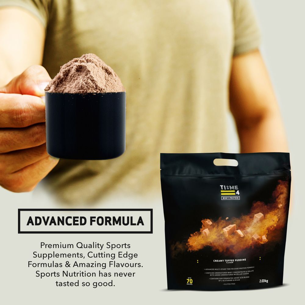 A hand holds a scoop of brown protein powder next to a bag of