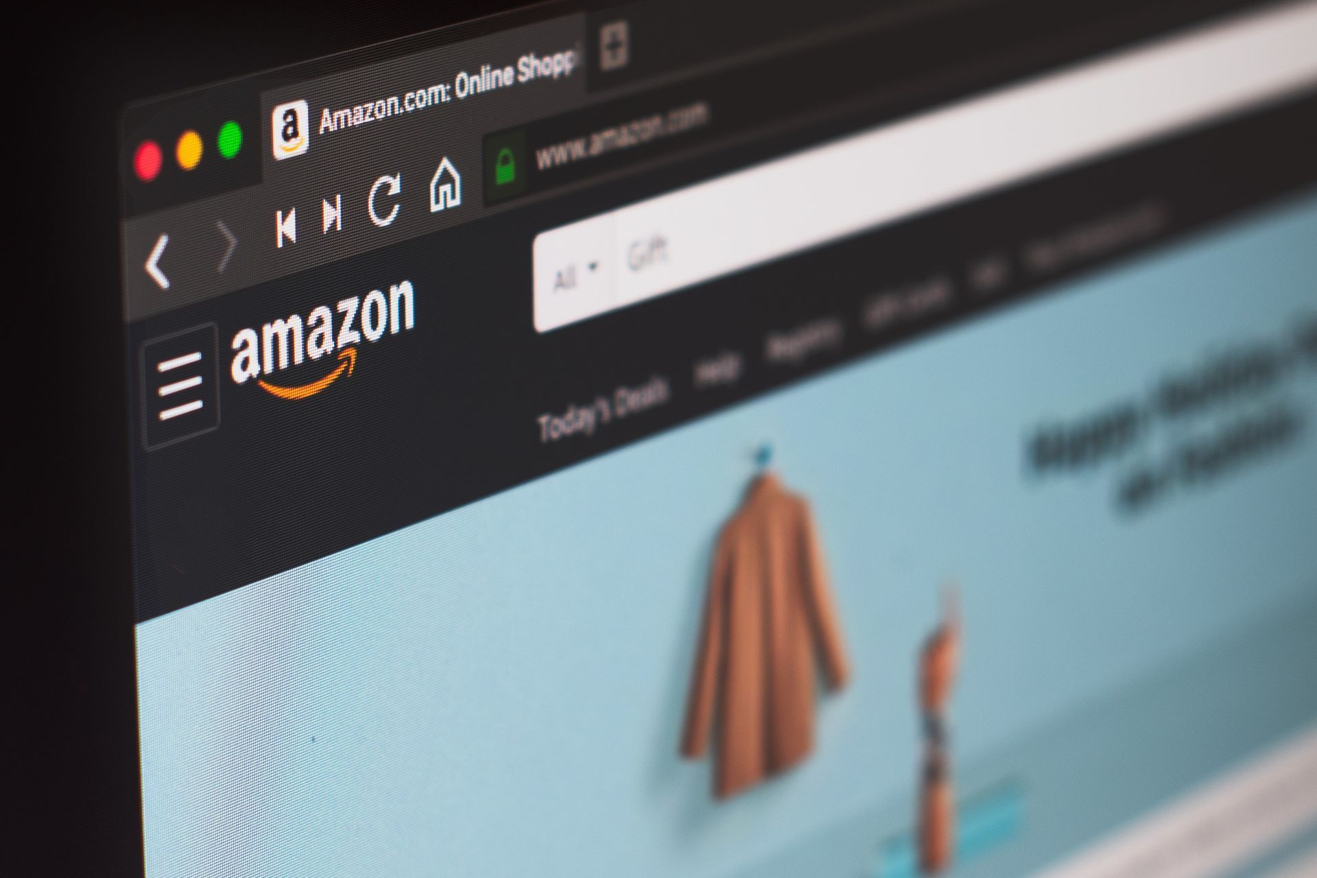 A close-up view of the Amazon homepage displayed on a computer screen, showing the logo and search bar.