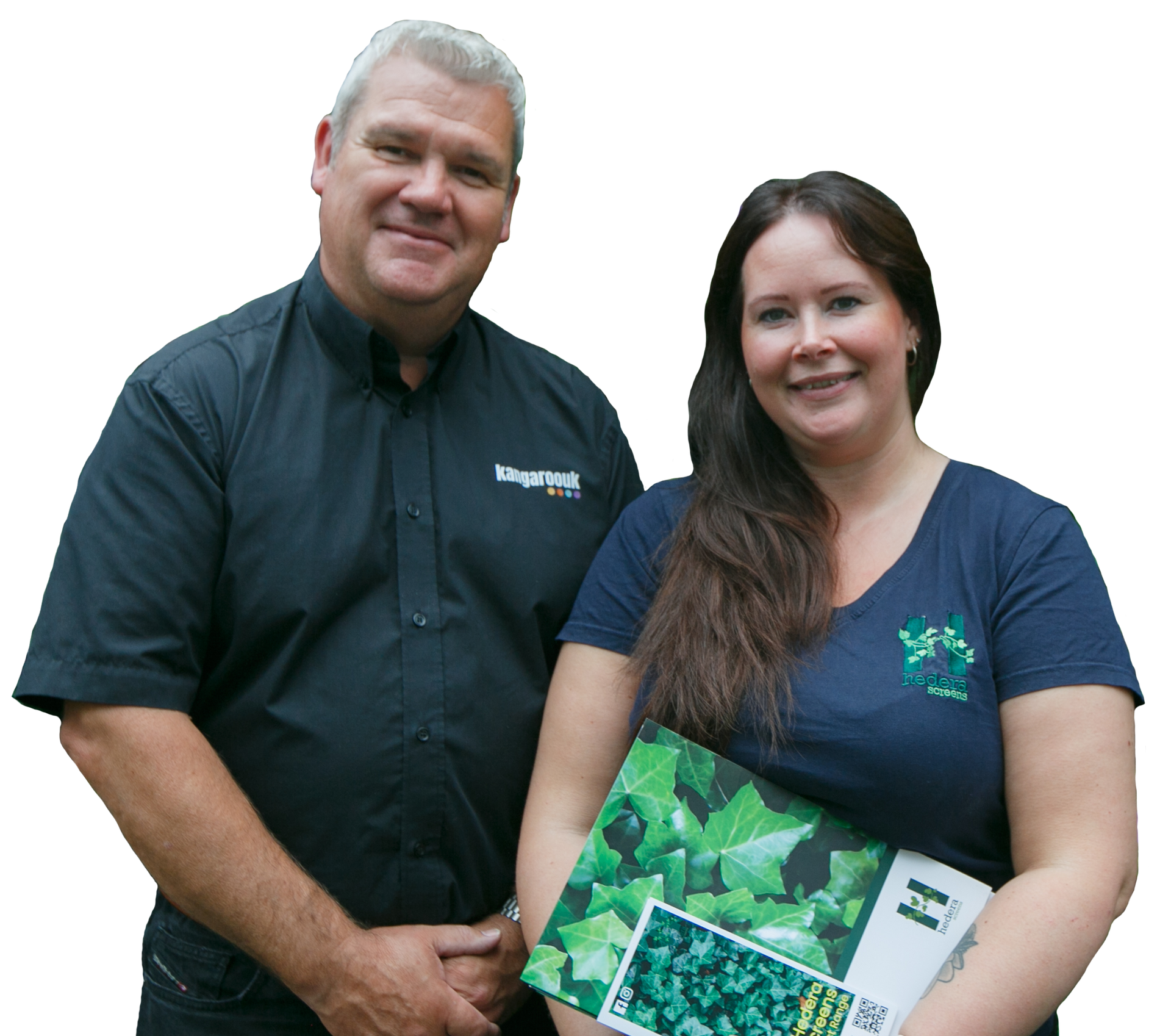A man and woman smiling at the camera; the woman holds a brochure with green plants on it.