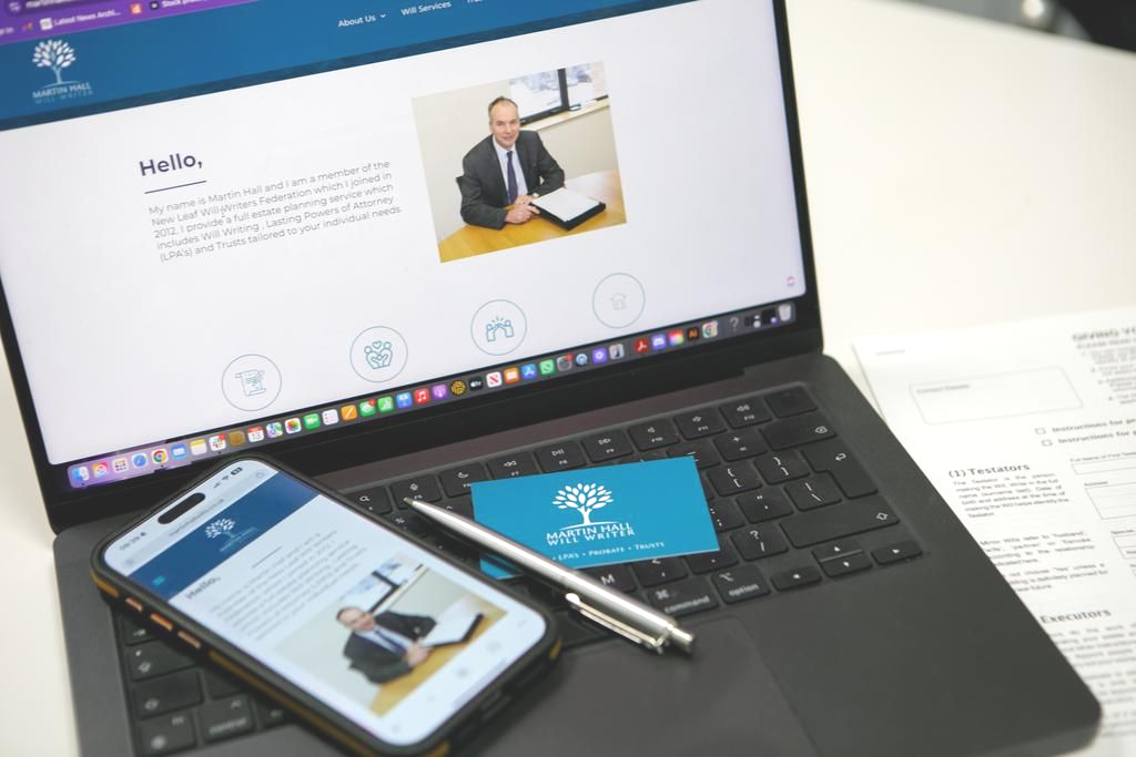 Laptop, phone, and business card with the same logo of a tree and website of a professional in office setting.
